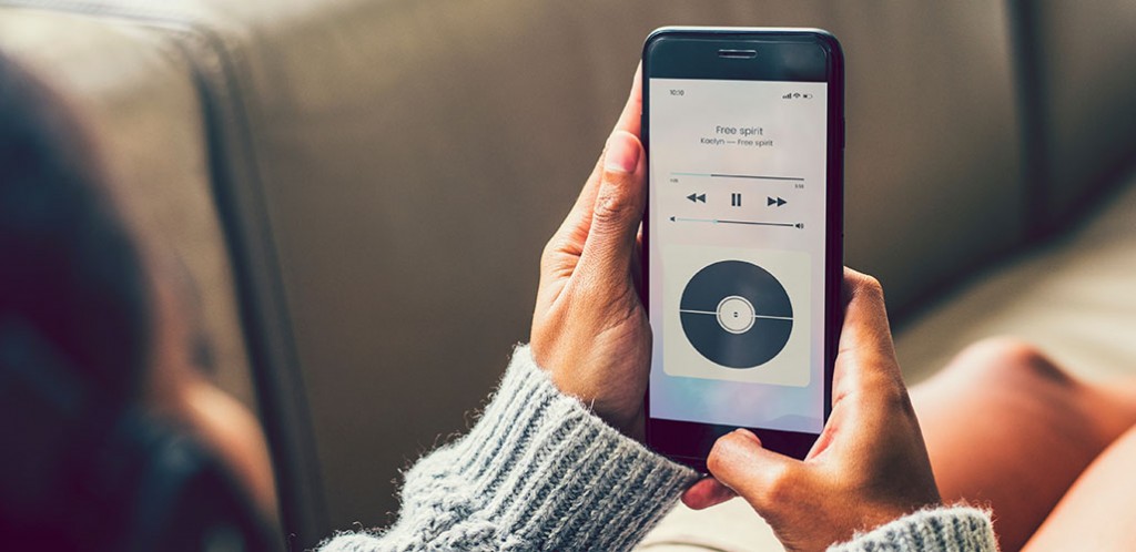 Nainen kuuntelee musiikkia puhelimella