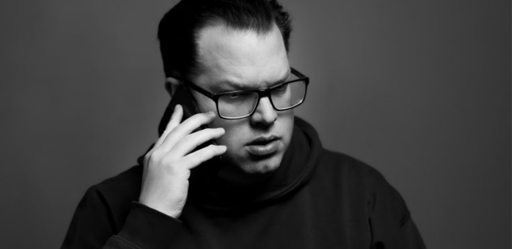 Säveltäjä ja tuottaja Jonas Olsson mustavalkoisessa kuvassa puhumassa puhelimeen