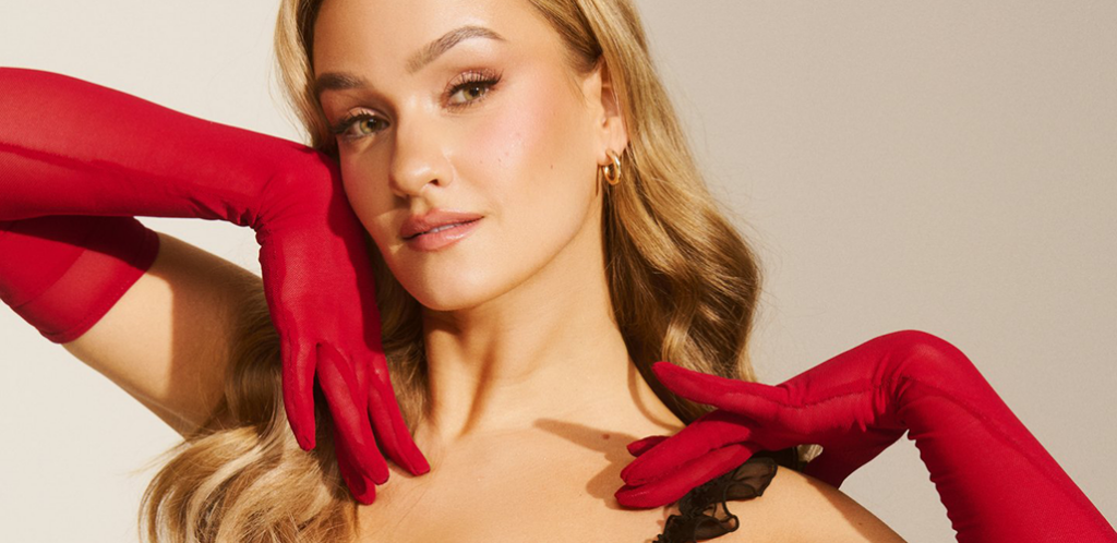 Artisti Nelli Matula lähikuvassa, pitkät punaiset hanskat käsissään.